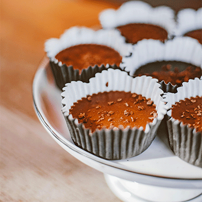 chocolate cupcakes in grey liners with chocolate shavings on top